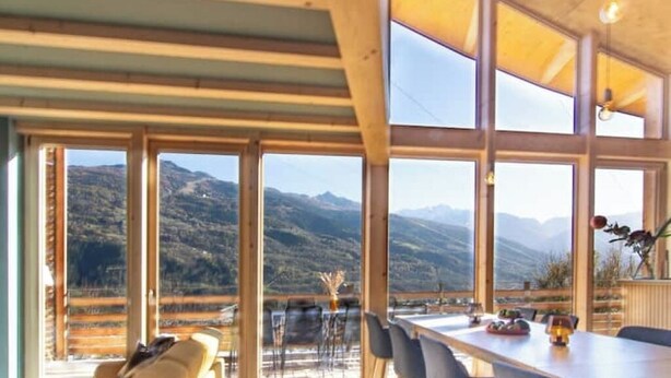 Amplia habitación con grandes ventanales que ofrecen vistas a la montaña.