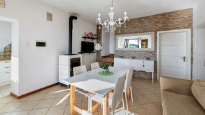 Una cocina moderna con comedor, una lámpara de araña y un revestimiento de pared de piedra.