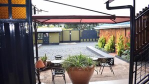 Ein Terrassenbereich im Freien mit einem großen Blumenkasten, einem Tisch und Stühlen.