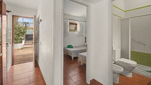 Ein Zimmer mit einem Bett, einem kleinen Tisch und einem Fenster.