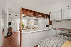 A modern kitchen with white cabinets, a granite countertop, and a built-in microwave. - Holiday Apartment 'Los Porches K29' with Shared Pool, Private Terrace & Wi-Fi (Playa del Inglés)