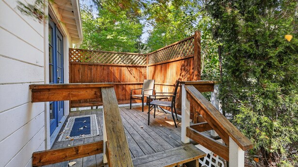A wooden deck with a blue door, two chairs, and a wooden fence. - Rouge Cobb Mountain Hotel - Cabin 5 (Cobb)