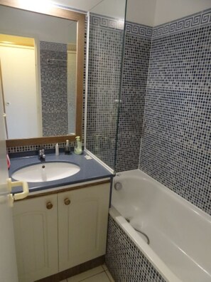 Ein Badezimmer mit Waschbecken, Spiegel und Badewanne.