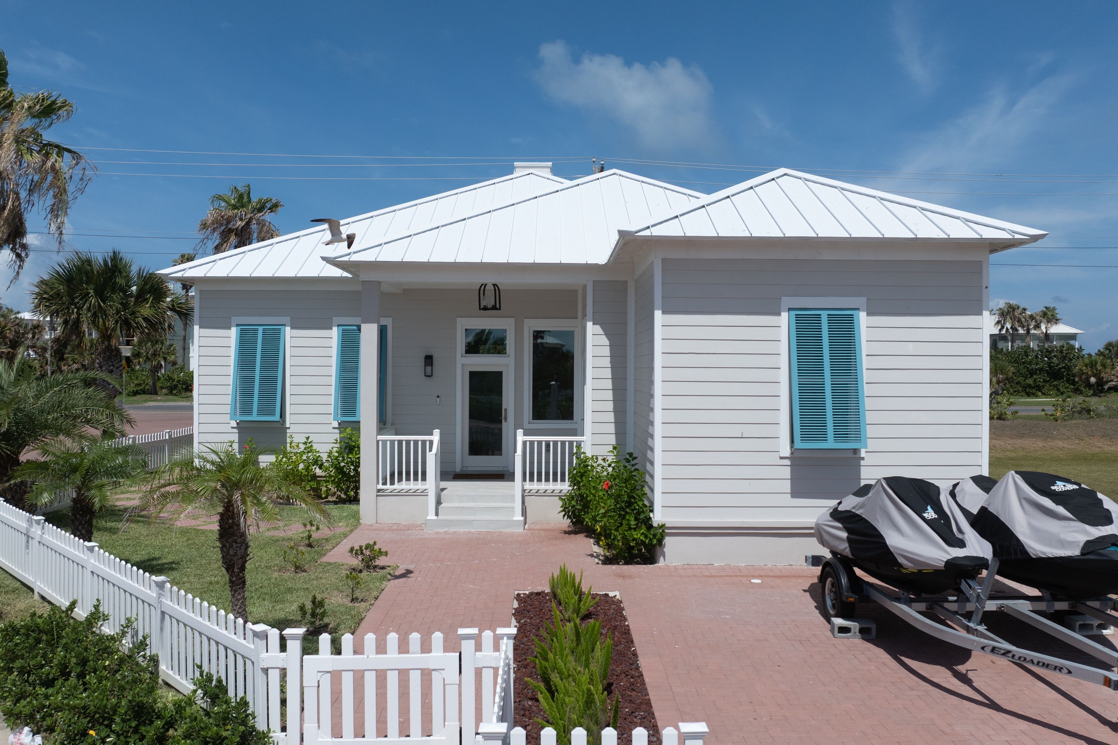 A single-story house with a front porch, a garage, and a covered boat trailer.