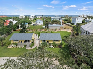 A residential area with houses, a well-maintained lawn, and a view of the ocean. - Steps to Beach Patio Fire Pit Tropical Oasis (St. Augustine)