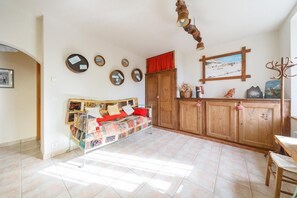 A room with a bed, a wooden cabinet, and a painting on the wall.