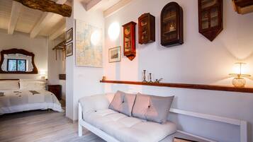 A bedroom with a bed, a sofa, a map on the wall, and several wooden cabinets.