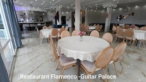 A restaurant interior with round tables, chairs, and a marble floor. - Guitar Palace (Bni Quolla)