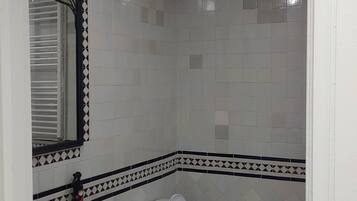 A bathroom with a toilet, sink, and shower.
