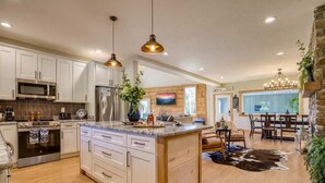 A modern kitchen with white cabinetry, stainless steel appliances, and a central island.