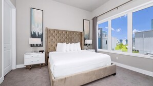 Un dormitorio moderno con una cama grande, una mesita de noche y una ventana con vistas a edificios.