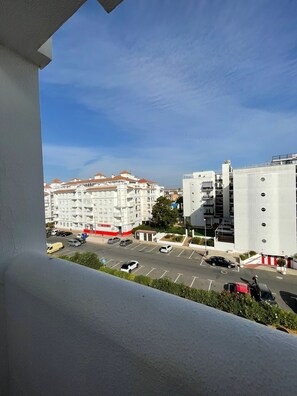 Un quartier résidentiel avec des immeubles à plusieurs étages, un parking et un ciel bleu dégagé.