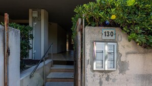 A staircase leading to a landing with a utility box labeled '130' and a metal railing. - GuestHost - Hopper House (Cagliari)