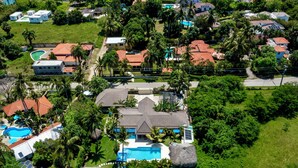 An aerial view of a residential area with houses, a swimming pool, and lush greenery. - SOSUA Luxury 9-BDR Villa : 20 Guests : POOL (Sosúa)