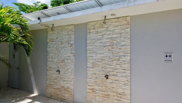 A building with stone walls and a sign indicating a men's restroom. - SOSUA Luxury 9-BDR Villa : 20 Guests : POOL (Sosúa)