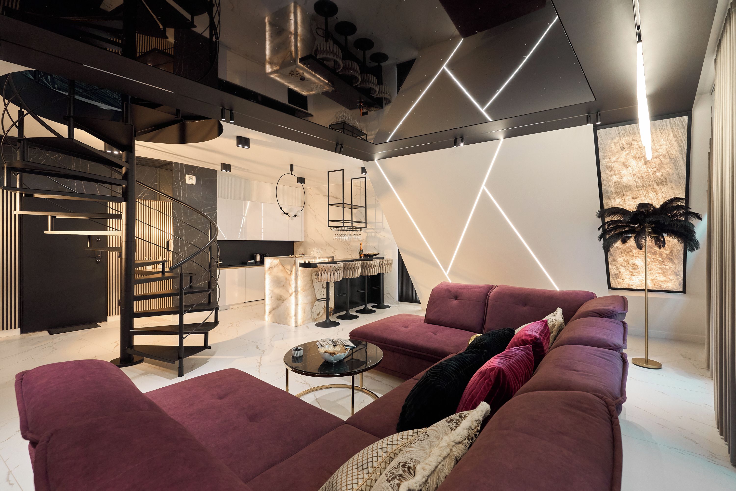 A modern living room with a sofa, a coffee table, and a kitchen in the background.