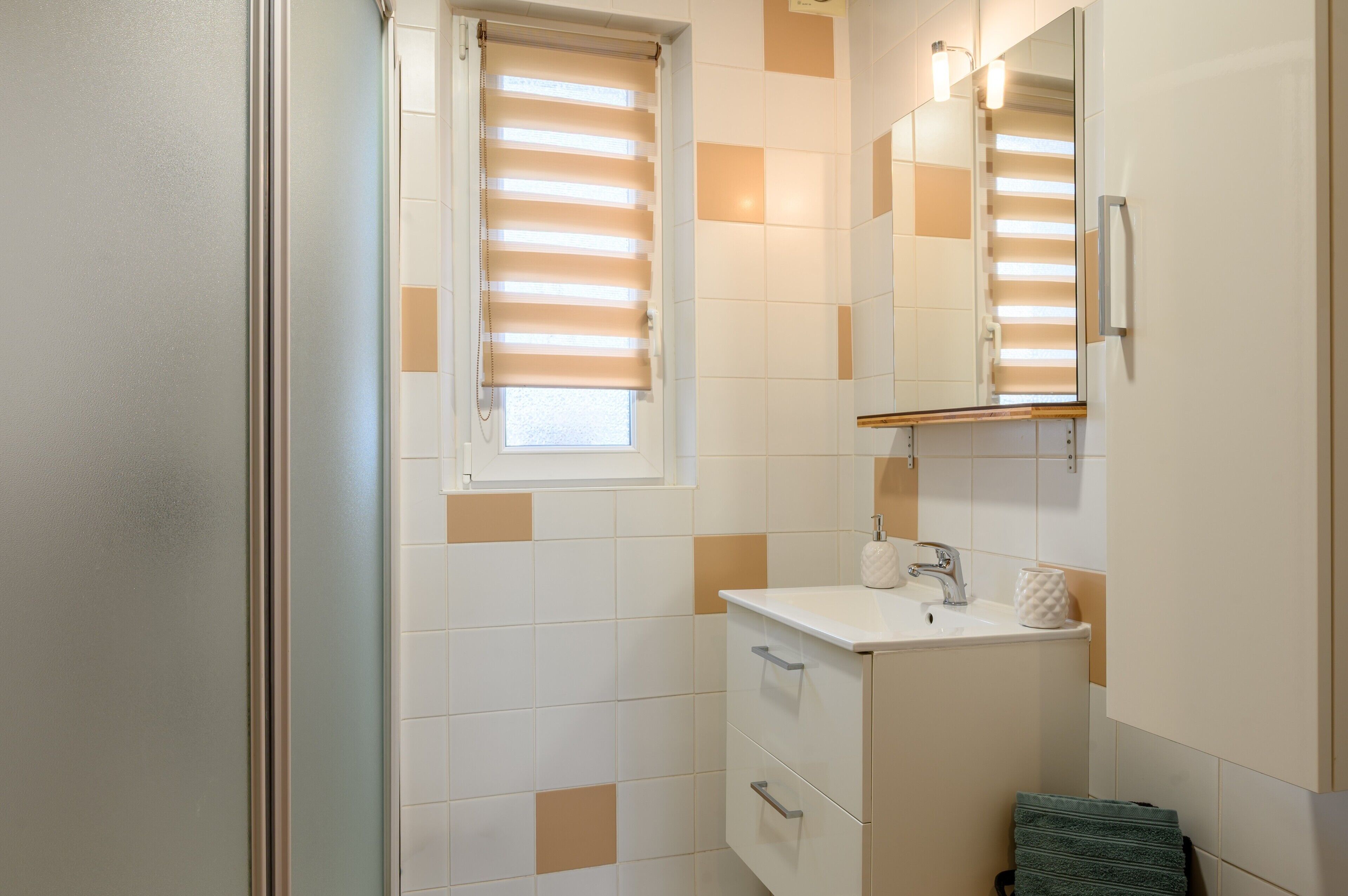 Ein Badezimmer mit Waschbecken, Spiegel und Handtuchhalter.