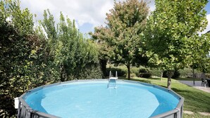 An above-ground swimming pool with a ladder, surrounded by lush greenery and trees. - Villa 'Relax' with Mountain View, Wi-Fi and Air Conditioning (Ruviano)