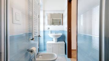 A bathroom with a white sink, a mirror, and a toilet.