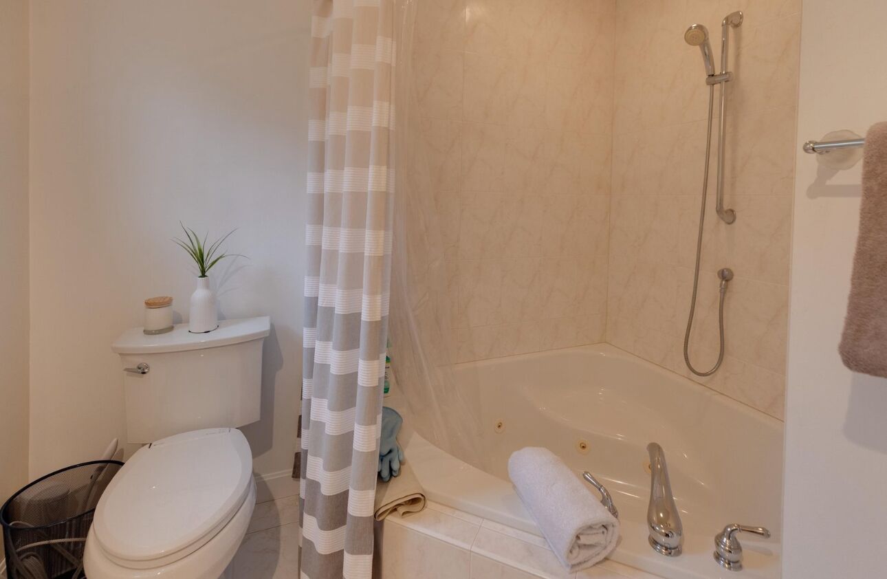 A bathroom with a toilet, shower, and bathtub.