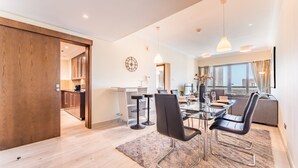 Un salon moderne avec un coin repas, de grandes fenêtres et une vue sur la ville.