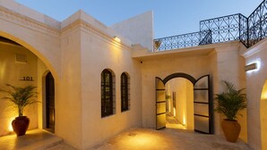 Ein Hotel mit Eingangsbereich, einer Rezeption, nummerierten Zimmern und Blumentöpfen.