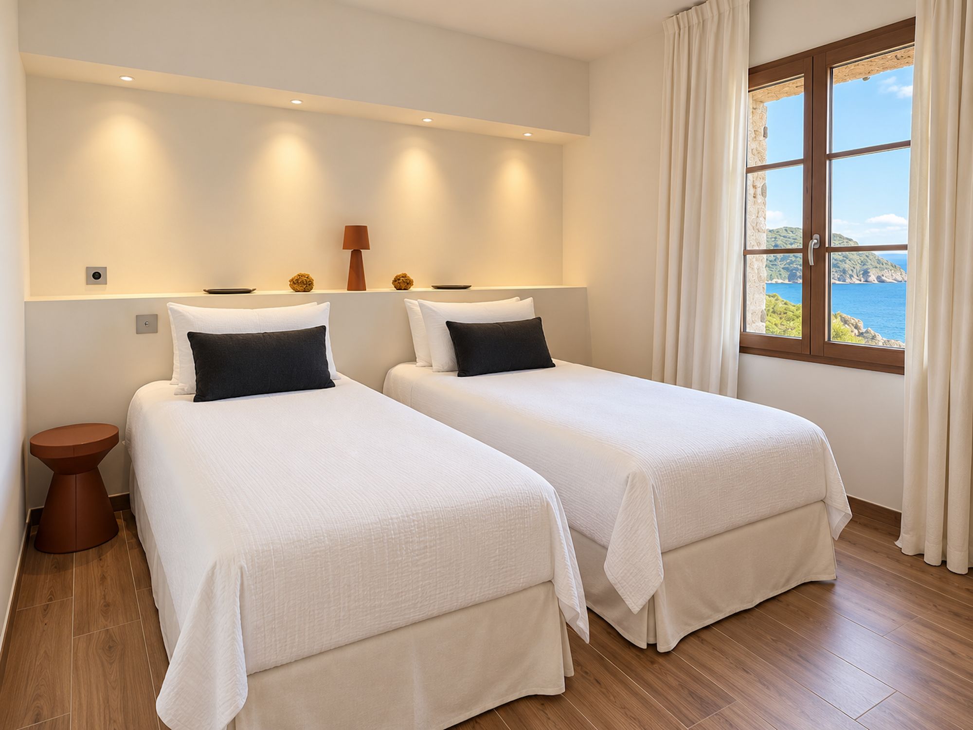 Habitación de hotel con dos camas, una ventana con vistas y suelo de madera.