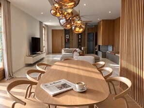 A modern dining area with a wooden table, chairs, and a newspaper.