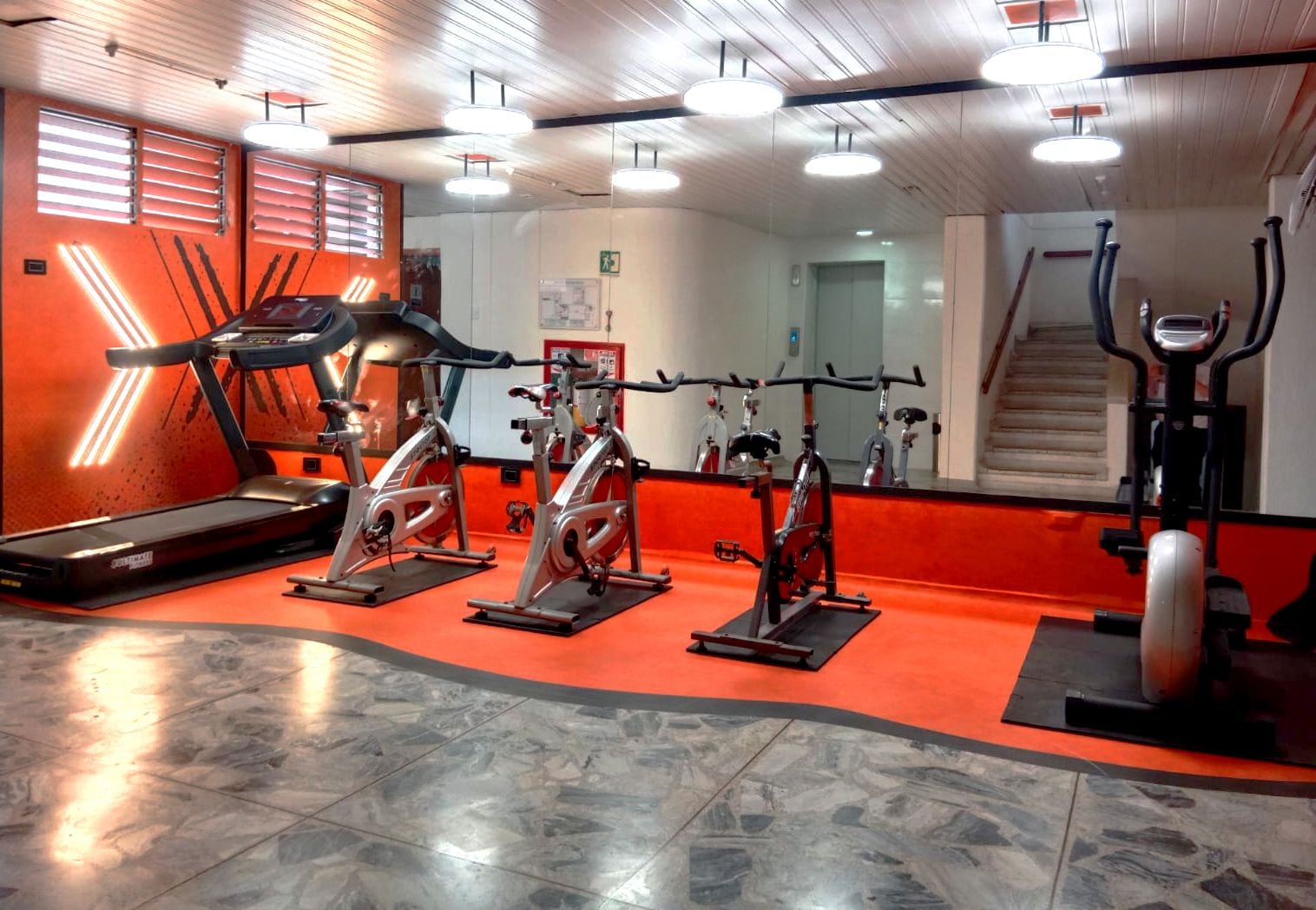 Ein Fitnessstudio mit Laufbändern, Ergometer und einem Steiger.