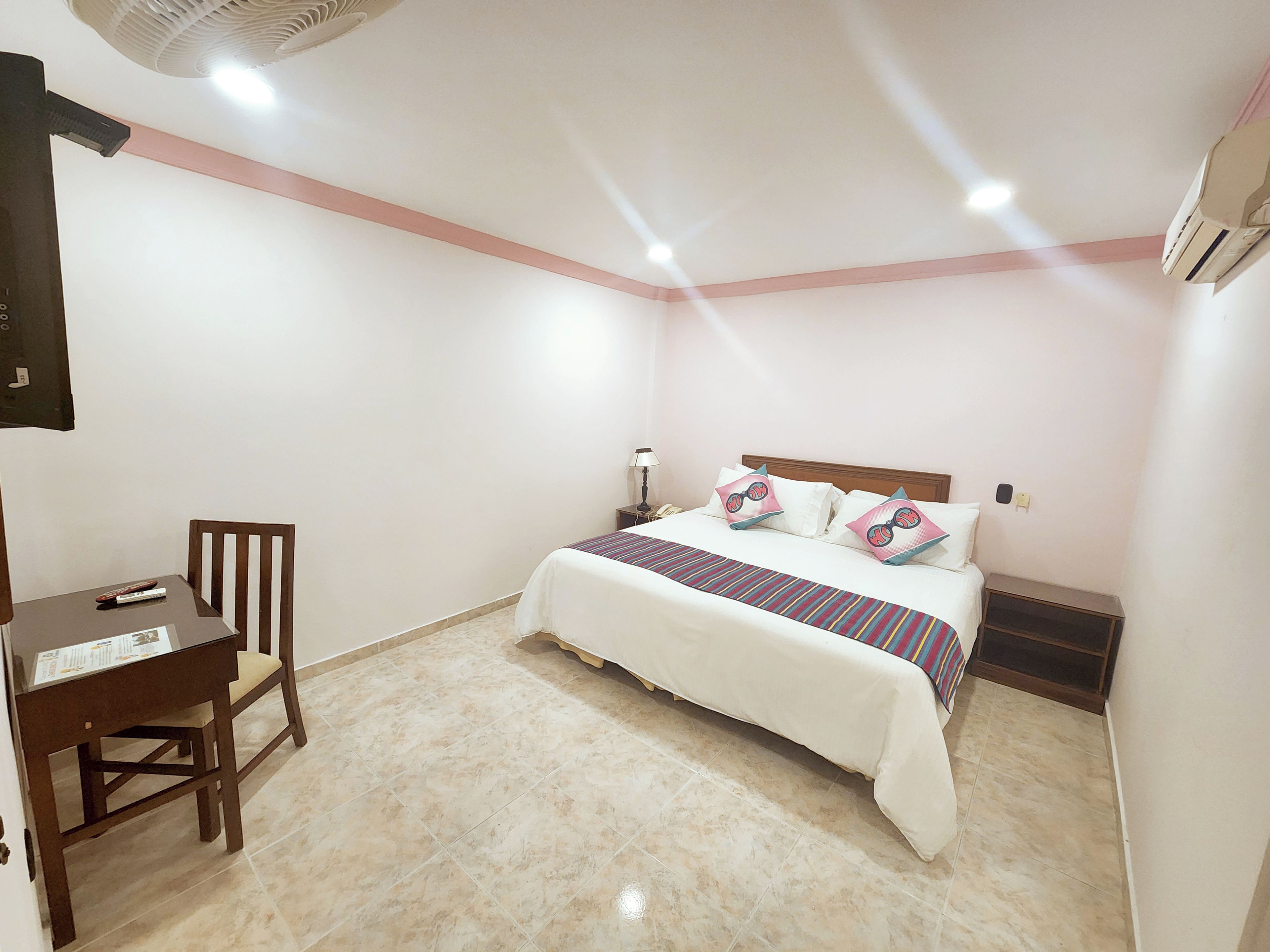 Una habitación de hotel con cama, escritorio y silla.