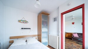 A bedroom with a wooden bed, a radiator, and a mirror with a red frame.