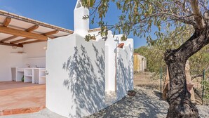 A white building with a pergola and a tree in the foreground. - Independent Domu Fama (Tertenia)