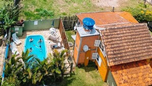 Une piscine entourée de chaises longues et un bâtiment doté d’un toit en tuiles.
