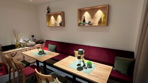 A modern living room with a wooden dining table, two sofas, and a small kitchen area. - Apartment Ahrblick (1-4 persons) | Top vacation apartment with a view of the Ahr (Altenahr)