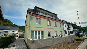 A two-story building with a flat roof, multiple windows, and a balcony. - Apartment Ahrblick (1-4 persons) | Top vacation apartment with a view of the Ahr (Altenahr)