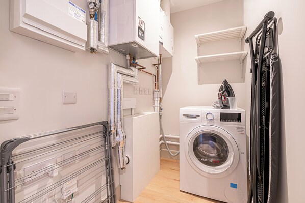 A laundry area with a washing machine, dryer, and stacked laundry baskets.