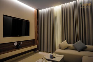 A modern living room with a flat-screen TV, a sofa, and a coffee table. - Aswar Plus for serviced apartments (Tabuk)