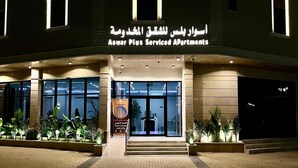 A building with a sign reading "Aswar Plus Serviced Apartments" at night. - Aswar Plus for serviced apartments (Tabuk)