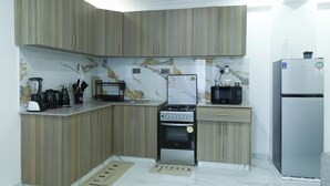Une cuisine moderne avec des meubles en bois, un four encastré, un four à micro-ondes et un réfrigérateur.
