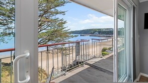 Un balcon avec vue sur la mer et un bâtiment situé au loin.