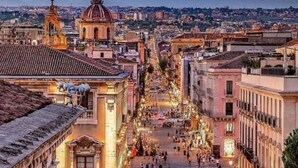 Escena callejera animada con edificios históricos y una cúpula destacada.