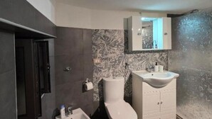 Un baño moderno con inodoro, lavabo y mueble.