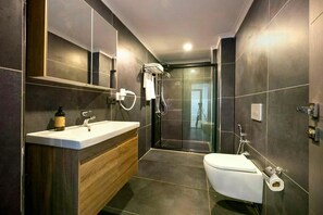 Chuveiro, secador de cabelo, chinelos, toalhas de banho