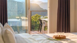 A hotel room with a bed, a table with a tray, and a view of a balcony with a chair and a table. - Viva Pension Nami Island, Gapyeong (Gapyeong)