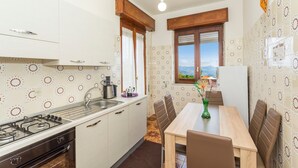 Une cuisine compacte équipée d’une cuisinière, d’un évier et d’un coin repas avec des chaises et une table.