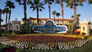 A Westgate Lakes Resort & Spa sign with palm trees and a flower garden. - Wesgate Lakes Resort (Orlando)