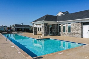 A pool area with a stone building labeled "NOW LEASING" and a clear blue sky. - Modern King Loft Parking W D Wifi Pool (Westerville)