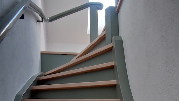 A staircase with a handrail and a window at the top. - Apartment 'Ferienwohnung Für Max 2 Personen' (Hannover)