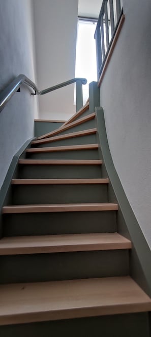 Un escalier avec une rampe et une fenêtre en haut.