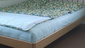 A bed with a metal frame, a patterned bedspread, and a plain wall. - Apartment 'Ferienwohnung Für Max 2 Personen' (Hannover)
